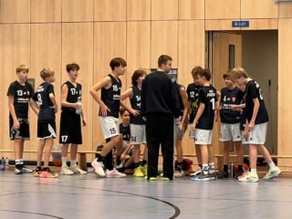 Mu14-LL vs. Tiger 76-47 Am frühen Samstag morgen ging es für unsere mu14-2 nach Kreuzberg. Für uns war das Ziel, möglichst intensiv zu verteidigen und mit dem Ball schnell Richtung Korb zu kommen.
Das klappte am Anfang direkt sehr gut, wir haben körperlich aber fair verteidigt und deshalb viele schnelle Angriffe erspielt.
Wir haben viele gute Würfe geworfen, leider war anfangs nur kaum was drin. Uns war das egal, abhaken und weitermachen war unsere Lösung dafür.
Die Tiger haben ebenfalls sehr schnell gespielt, was uns immer wieder an unsere Grenzen brachte, dazu viele einige Würfe rein. Zur Halbzeit lagen wir knapp hinten. In die zweite Hälfte starteten wir extrem motiviert, mehr Pässe abzufangen und mehr zum Korb zu kommen.
Jetzt belohnten wir uns auch mehr, trafen einige gut erspielte Dreier und so wuchs unser Vorsprung immer mehr. Am Ende gewinnen wir deutlich gegen das ebenfalls sehr junge Tiger Team setzen unsere kurze aber heiße Win-Streak fort.