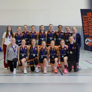 Am vergangenen Wochenende spielte auch die wu14-1 im Top4 der Oberliga um die Berliner Meisterschaft.
Da es mit BASS in der Hauptrunde nur ein Team gab, dass uns knapp schlagen konnte, zogen wir als zweiter und nicht gerade als Underdog in die Halbfinalpartie gegen den Drittplatzierten ALBA BERLIN 1 ein.
Optimistisch und positiv aufgeregt gingen wir in die Partie. Wie immer starteten wir mit voller Intensität in der Defense, um daraus in den Fastbreak und ins Laufen zu kommen. Bei ALBA reicht es zwar nie aus, lediglich einzelne Spielerinnen in Schach zu halten, aber wir wussten schon um deren Stärken, versuchten diese soweit wie möglich zu kontrollieren und kontrollierten damit das Spiel.
Mit +12 zur Halbzeit war das Spiel zwar noch nicht durch, als wir dann mit 53:30 in die letzte Pause gingen konnten wir aber schon ein kleines bisschen durchatmen. In den letzten 10 Minuten rotierten wir viel und ließen ALBA so ein wenig rankommen, der Sieg, Einzug ins Finale und damit historische Einheit Pankow Erfolg konnte uns aber nicht mehr genommen werden. 64:46 Am Tag darauf ging es dann im Finale gegen BASS.
Leider mussten wir aufgrund verletzter Knöchel vom Vortag auf gleich drei wichtige Spielerinnen verzichten.
Die Aufgaben mussten nun spontan neu verteilt werden. Vor allem auf der Guard-Position bekamen wir Schwierigkeiten. Ungünstig, wenn BASS immer sehr viel Druck am Ball macht. Unsere 2 Jahre jüngere Enna übernimmt stark, bringt den Ball sicher ins Vorfeld und koordiniert das Spiel, aber sie kann und soll nicht 40 Minuten spielen. Auch Lori, die die gesamte Saison über eine wichtige Stütze war, lässt sich von den Umständen nicht aufhalten und ackert an allen Enden. Alle Mädels geben ihr bestes, wir haben gutes Ballmovement, sehen schöne Optionen, greifen bei den Rebounds zu, nur Punkte gibt es zu wenige. In Defense reicht es für die schnellen BASS Girls immer mal wieder nicht: jeder Unaufmerksamkeit wird ausgenutzt. Und so wird der Abstand immer größer, obwohl sich das Spiel gar nicht so anfühlt. 45:71 Natürlich ist die Enttäuschung im ersten Moment groß, aber es dauerte nicht lang, zu realisieren, was wir geschafft haben: 🎊VIZEMEISTERINNEN!!!! 🥈