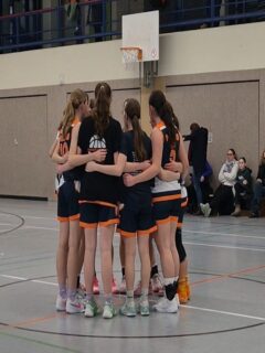 Saisonbericht wu16-1
Die wu16-1 startete hochmotiviert und voller Vorfreude in die OL-Saison 2025/26. Von Beginn an war klar, dass uns ein paar u14erinnen helfen sollten, da der 2011er Jahrgang mittlerweile auf zwei letzte Urgesteine zusammen geschrumpft war. Wie sehr wir auf die wu14 angewiesen sein würden, konnten wir im September noch nicht ahnen.  Mit 12 Teams in der Liga hatten wir einen eng getakteten Spielplan vor uns. Jedoch zwangen uns mehrere Verletzungen dazu, immer mehr Spiele nach hinten zu schieben. So hatten wir bis Ende des Jahres einen sehr zerrupften Spielplan und kamen nur schwer ins Rollen. Gegen Gegnerinnen aus der unteren Tabellenhälfte fiel das nicht so sehr ins Gewicht und oft bestand der Kader aus mehr u14ern als u16er. Spielerinnen, die ursprünglich (noch) gar nicht für die OL eingeplant waren, nutzten ihre Chance, und erspielten sich so einen festen Platz im Kader.
Ausgerechnet gegen ALBA 2 im Dezember hatten wir vorher 3 Wochen Pause und performten nicht gerade eingespielt. Das Ergebnis: die erste Niederlage der Saison.
Am Ende gingen wir nach 22 Spielen mit 5 Niederlagen raus, wobei davon nur 3 gespielt wurden. Leider mussten wir nämlich beide Spiele gegen ALBA 1 immer wieder schieben und am Ende absagen, was uns zusätzlich Wertungs-Minuspunkte einbrachte. Nichtsdestotrotz war der Abstand zu Platz 5 groß genug, sodass wir uns für das Top4 qualifizierten.  Eine neue Regelung führte dazu, dass wir keine Aushilfen aus der u14 für diesen wichtigen Saisonhöhepunkt bekamen, und das obwohl diese Spielerinnen teilweise maßgeblich für den Saisonverlauf verantwortlich waren. Eine weitere Verletzung reduzierte unseren Kader auf 8 Spielerinnen, wovon drei bisher noch gar nicht oder nur vereinzelt Spiele in der Saison für die OL absolvierten. 
Entsprechend herausfordernd gestaltete sich das Wochenende für uns. Der 4. Platz war folgerichtig, aber nichtsdestotrotz ein starkes Ergebnis für eine Saison, die so gar nicht nach Plan verlief. Umso stolzer sind wir auf alles, was wir erreicht haben.  Für die wu16-1 spielten
Luise, Leo, Pheline, Mette, Paula, Malin, Karo, Lotta, Luzie, Greta, Tildi, Lori, Jara, Mathi, Lotti, Hella, Maggie, Amelie, Loubna